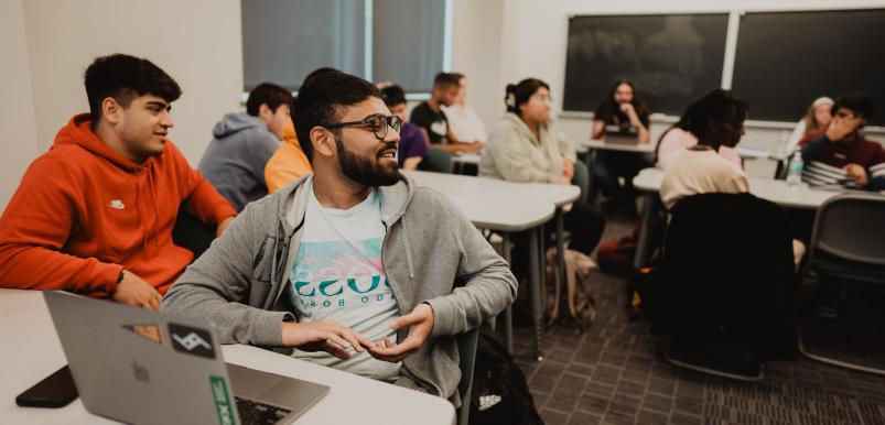 A student speaks to the room in the middle of an economics class.